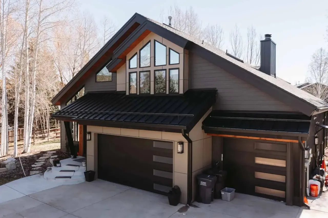 A Park City home among aspen trees with a black standing seam metal roof by Copper Hammer Roofing